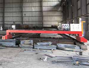Big red CNC cutter in large industrial warehouse