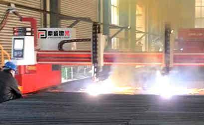 Worker near red flame cutting machine doing cutting work